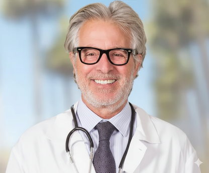 Doctor wearing a white coat with a stethoscope, smiling against a blurred outdoor background